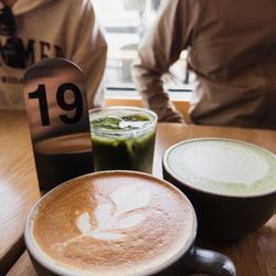 Mast Coffee - Dirty Chai latte (front) and a hot and iced Tokyo Fog (FLORAL BLACK METALLIC TEA INFUSED OAT MILK W/ CEREMONIAL MATCHA. 12 OZ HOT OR ICED)