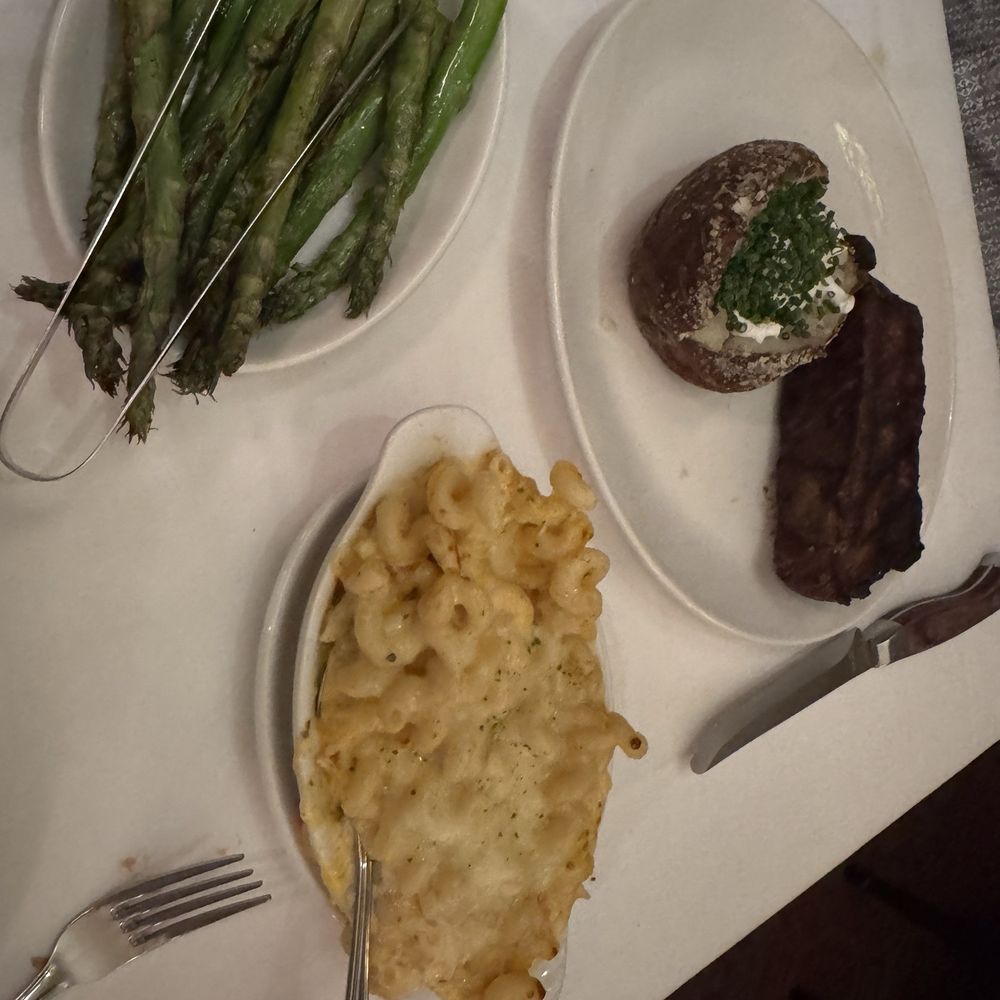 St. Elmo Steak House - Prime dry- aged New York Steak with the baked potato, side of king crab mac & cheese and side of asparagus - Steakhouses Near Me - Indianapolis, Indiana St. Elmo Steak House - Prime dry- aged New York Steak with the baked potato, side of king crab mac & cheese and side of asparagus - Steakhouses Near Me - Indianapolis, Indiana