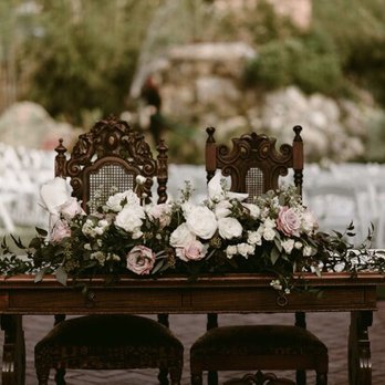 Beatitude Flower Arrangements - Couples table was adorned with a bounty of roses and ranunculus flowers that added to a garden-like feel. - Florists Near Me Beatitude Flower Arrangements - Couples table was adorned with a bounty of roses and ranunculus flowers that added to a garden-like feel. - Florists Near Me