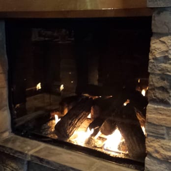 Pier 500 - Cozy Fireplace. There's one table for two and another large, round table right next to this. - American Near Me - Hudson, Wisconsin