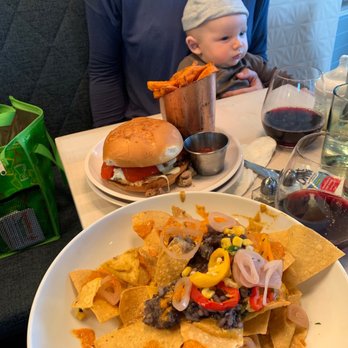 Naïve - Seasonal nachos, chicken pesto sandwich and lil guy are all in this photo. - New American Near Me - Louisville, Kentucky