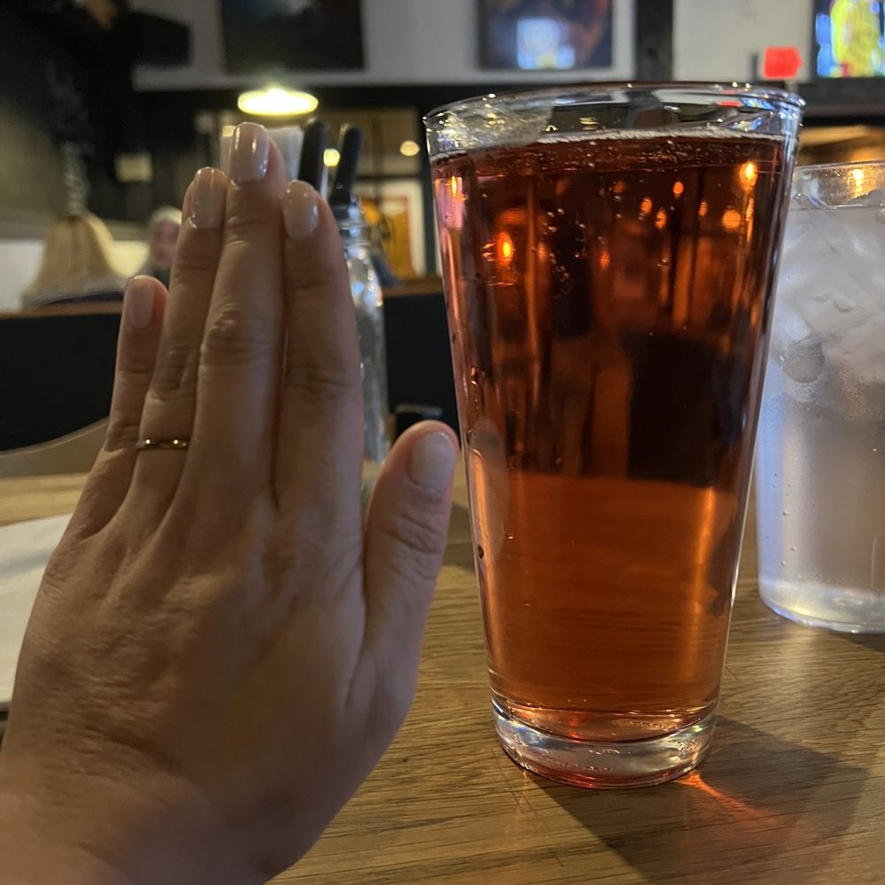 SaltFire Brewing Co Taphouse - a hand holding a glass of beer - American Near Me - Tempe, Arizona SaltFire Brewing Co Taphouse - a hand holding a glass of beer - American Near Me - Tempe, Arizona