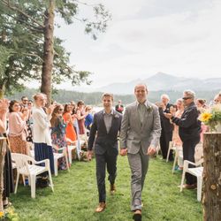 Rachel Konsella Photography - A wedding couple walking down the isle with a mountain backdrop