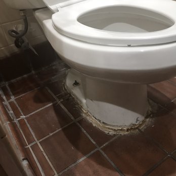 Outback Steakhouse - Lime buildup on tile and rust and goose buildup around the toilet. - Steakhouses Near Me - Burbank, California