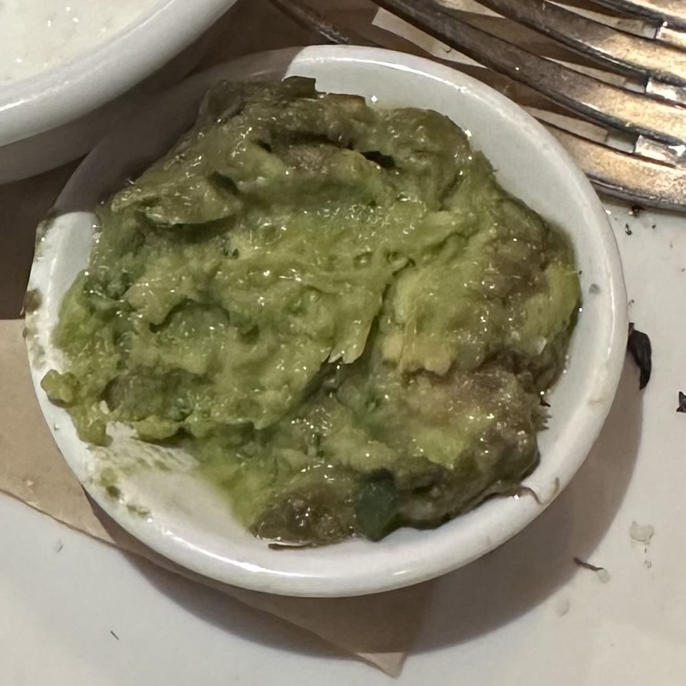 Seasons 52 - Small side of guac that came with my tacos.  The brown crust surprised me. - New American Near Me - North Bethesda, Maryland