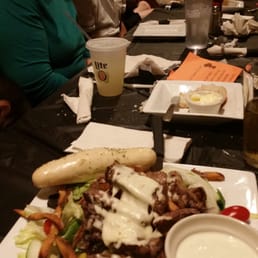 a group of people sitting at a table with plates of food a group of people sitting at a table with plates of food