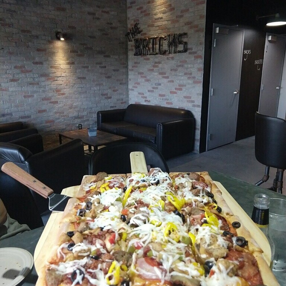Bricks Restaurant - a large pizza on a table - Pizza Near Me - Olsburg, Kansas Bricks Restaurant - a large pizza on a table - Pizza Near Me - Olsburg, Kansas