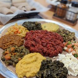 Ahadu Ethiopian Cuisine - Kifto (spicy raw beef) in the center + collard greens & homemade cheese and veggie combo 2 all on 1 large platter