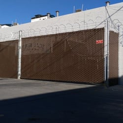 Ed's Fencing - Chain link fence with 3-strand barbed wire, razor ribbon and brown privacy slats