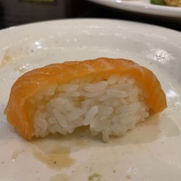 Salmon "sushi" - my A4 printer paper is thicker than this salmon - A single piece of salmon nigiri sushi with rice and a slice of salmon on top, served on a white plate.