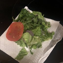 Wilted lettuce pieces and one tiny slice end of tomato Wilted lettuce pieces and one tiny slice end of tomato