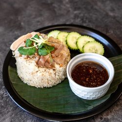 Rice Box Kitchen - KHAO MUN GAI Poached chicken skinless chicken thigh over coconut, ginger and garlic rice served with soybean chili sauce.