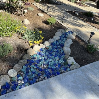 Growscapes - Native plants and dry creak with blue landscaping glass - Landscaping Near Me Growscapes - Native plants and dry creak with blue landscaping glass - Landscaping Near Me