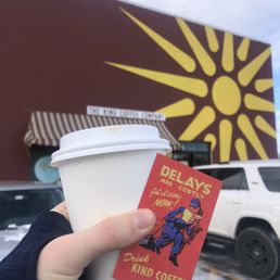 a hand holding a cup of coffee a hand holding a cup of coffee