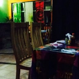 a table and chairs in a dimly lit room a table and chairs in a dimly lit room