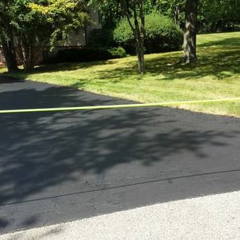 ABC Asphalt - a driveway with a yellow tape - General Contractors Near Me