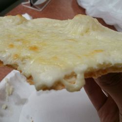 Pierre's Eatery - Here is a slice of their white pizza. Notice how thick the white sauce is on the tip of the pizza compared to the mozeralla layer.