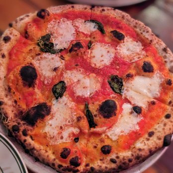 Roberta's - a pizza on a plate on a table - Pizza Near Me - Brooklyn, New York
