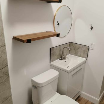Sophie's Renovations - a bathroom with a toilet, sink, and mirror - Carpenters Near Me Sophie's Renovations - a bathroom with a toilet, sink, and mirror - Carpenters Near Me