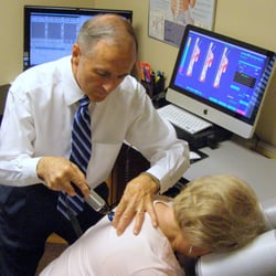 Living Well Chiropractic Clinic - Dr Wilcox adjusting a patient with the computerized adjusting instrument.
