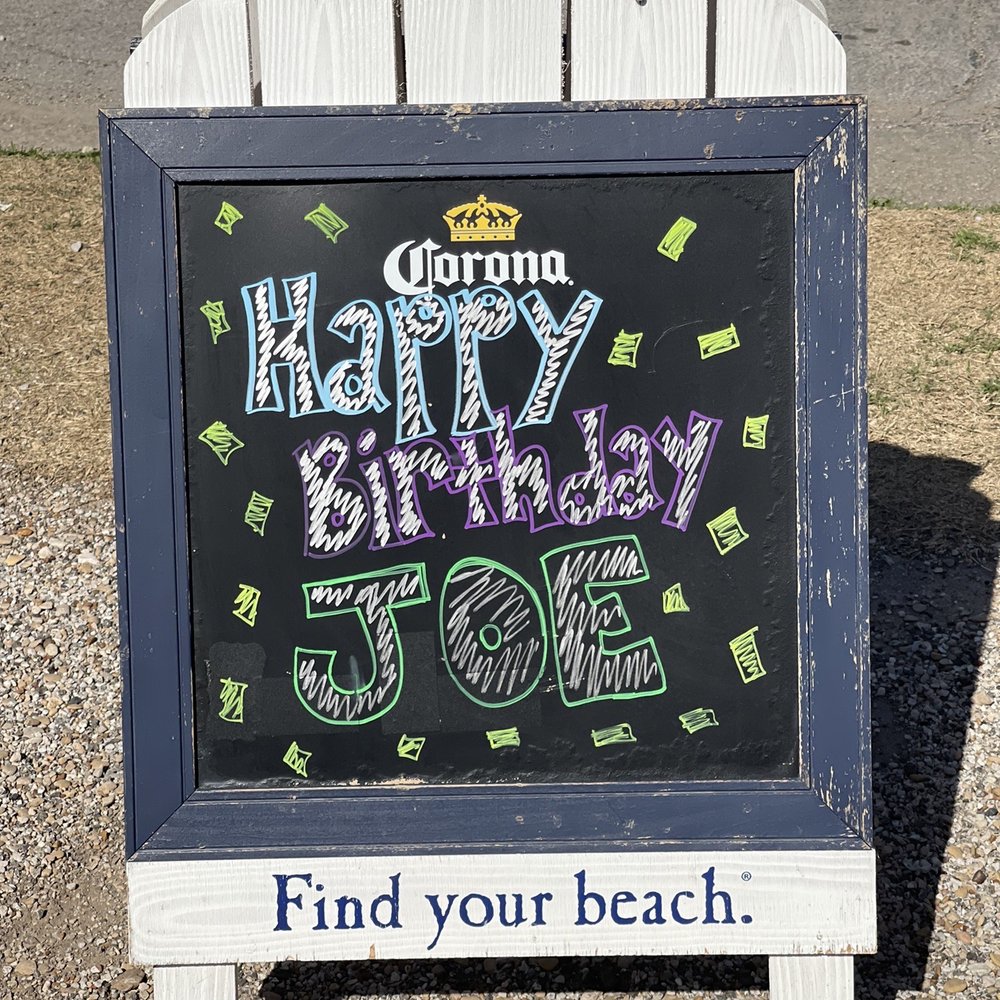 Barfly - a happy birthday sign in front of a beach chair - Dive Bars Near Me - Dallas, Texas