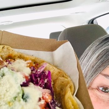 Tlaolli - a woman in a car with a taco - Mexican Near Me - Indianapolis, Indiana