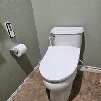 Zion Health Tech - The Smile Memory bidet with the cover closed and the remote control mounted on the wall. - Appliances Near Me - Los Angeles, California Zion Health Tech - The Smile Memory bidet with the cover closed and the remote control mounted on the wall. - Appliances Near Me - Los Angeles, California