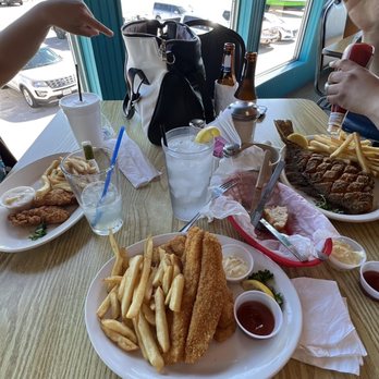 Waterfront - a woman sitting at a table with a plate of food - Seafood Near Me - Matagorda, Texas Waterfront - a woman sitting at a table with a plate of food - Seafood Near Me - Matagorda, Texas