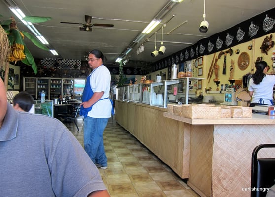 Photo of South Pacific Island Restaurant - Daly City, CA, US. Far left there's a kiosk of Polynesian items for sale.