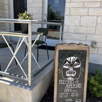 Hecho Amano Coffee - Right outside the coffee shop, a small patio table - Coffee & Tea Near Me - Pflugerville, Texas