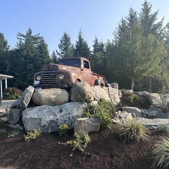 Zenji Landscape Construction - an old truck sitting on a pile of rocks - Landscaping Near Me