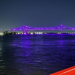 Riverboat City of New Orleans - Crescent city connection bridge lit up at night
