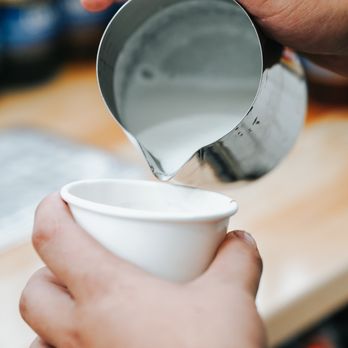 The Good Brew Cart - a person pouring milk into a cup - Coffee & Tea Near Me The Good Brew Cart - a person pouring milk into a cup - Coffee & Tea Near Me