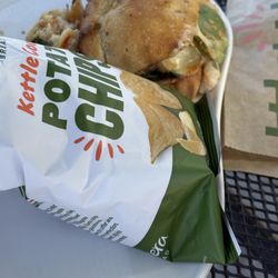 Panera Bread - Chipotle Chicken Avocado Melt sandwich and a side of chips.