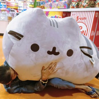 IT'SUGAR - a woman hugging a giant pusha cat - Candy Stores Near Me - San Antonio, Texas