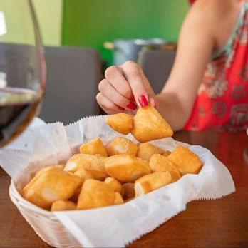 Rakija Lounge - a woman sitting at a table with a basket of food and a glass of wine - New American Near Me - Miami Beach, Florida Rakija Lounge - a woman sitting at a table with a basket of food and a glass of wine - New American Near Me - Miami Beach, Florida