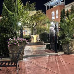 Gorgeous patio behind the hotel with tons of seating which you can't see. The pool is beyond the fountain. Gorgeous patio behind the hotel with tons of seating which you can't see. The pool is beyond the fountain.