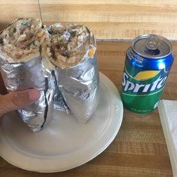 a person holding a plate with a burrito