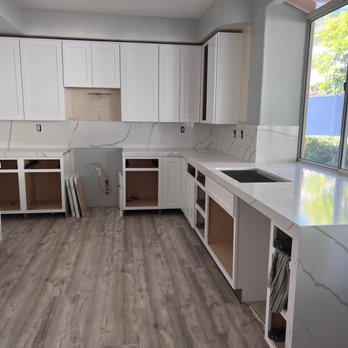 Royalty Stone - a kitchen with white cabinets and wood floors - General Contractors Near Me - Murrieta, California Royalty Stone - a kitchen with white cabinets and wood floors - General Contractors Near Me - Murrieta, California