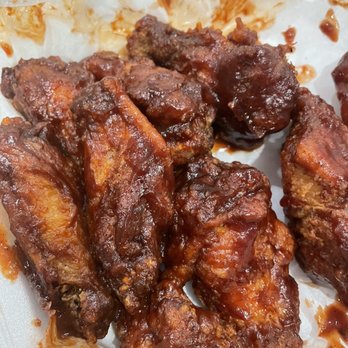 Sako's Pizza - BBQ wings - Barbecue chicken wings with sauce are shown in a foam takeout container, with some sauce residue on the container. - Pizza Near Me - Cranston, Rhode Island
