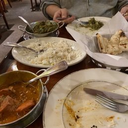 Chicken Tikka Masala, rice, Lamb Saag, and naan bread, already half eaten. Chicken Tikka Masala, rice, Lamb Saag, and naan bread, already half eaten.