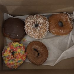Half dozen donuts minus one glazed donut that had already been eaten.