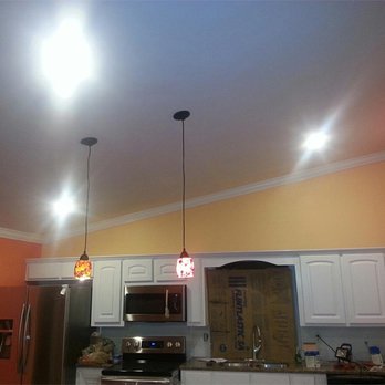 KC Roofing and Construction - a kitchen with orange walls and white cabinets - Roofing Near Me