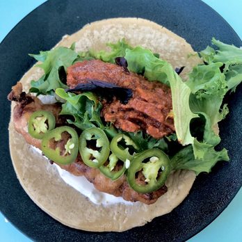 Lola 55 - Baja Fish Taco. local rock fish, remoulade, tomato vinaigrette, baby mizuna, pickled serrano, purple basil, jalapeño slices - Mexican Near Me - San Diego, California