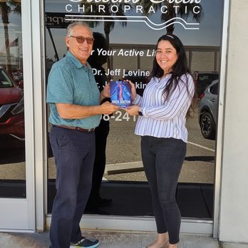 Stevens Creek Chiropractic - Dr. Levine & Receptionist Cinthia with Dr. Levine's book - Chiropractors Near Me - Santa Clara, California Stevens Creek Chiropractic - Dr. Levine & Receptionist Cinthia with Dr. Levine's book - Chiropractors Near Me - Santa Clara, California