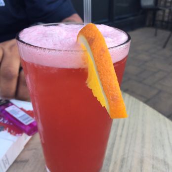 Embers - a red drink with an orange slice on the rim - New American Near Me - Claymont, Delaware
