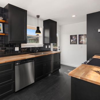 Unique Home Construction - a kitchen with black cabinets - Interior Design Near Me - Seattle, Washington Unique Home Construction - a kitchen with black cabinets - Interior Design Near Me - Seattle, Washington