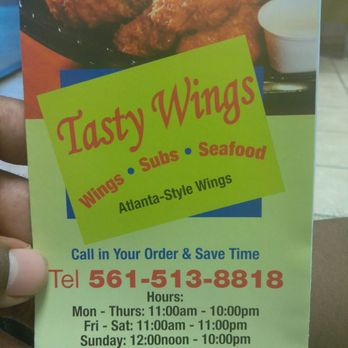 Tasty Wings - a hand holding a sign for a restaurant - Chicken Wings Near Me - Mangonia Park, Florida