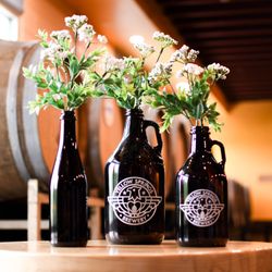 Yellow Springs Brewery - Growler, Howler and bottle flower presentation in front of our fermentation barrels.