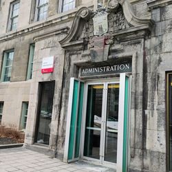 Université McGill - See the little frog statue at the top of the entrance? Queen's University students used to spray paint it purple as a prank.